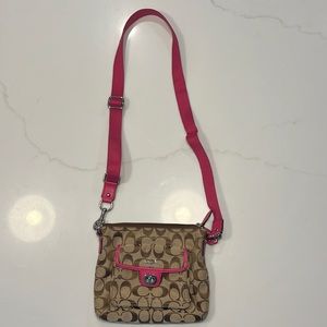 Coach cross body bag with pink detail. Zip closure.